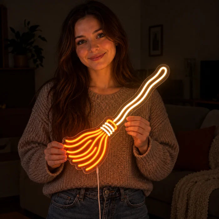 Noidan luuta neon LED -kyltti hymyilevän naisen käsissä tummaa taustaa vasten