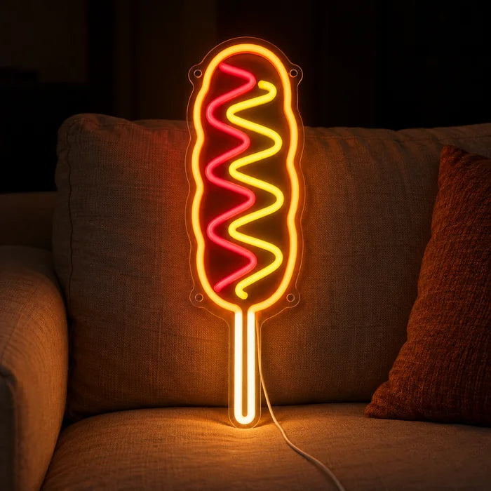 Corn Dog Neon LED Sign on a cosy sofa between cushions and a throw