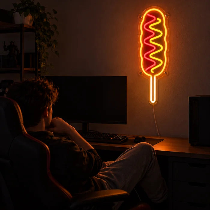 Corn Dog Neon LED Sign above a gaming desk, a gamer in a gaming chair in front of it