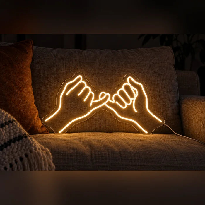 Pinky Promise Neon LED Sign on a cosy sofa between cushions and a throw