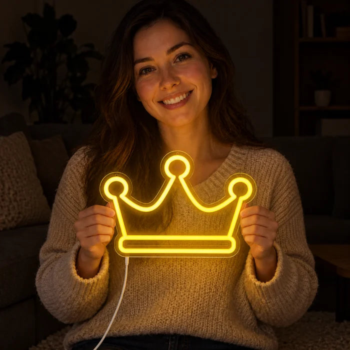 שלט ניאון LED כתר מלכותי בידיה של אישה מחייכת מול רקע כהה