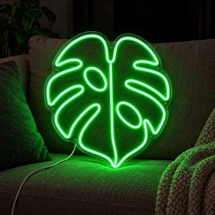 Monstera Leaf Neon LED Sign on a cosy sofa between cushions and a throw