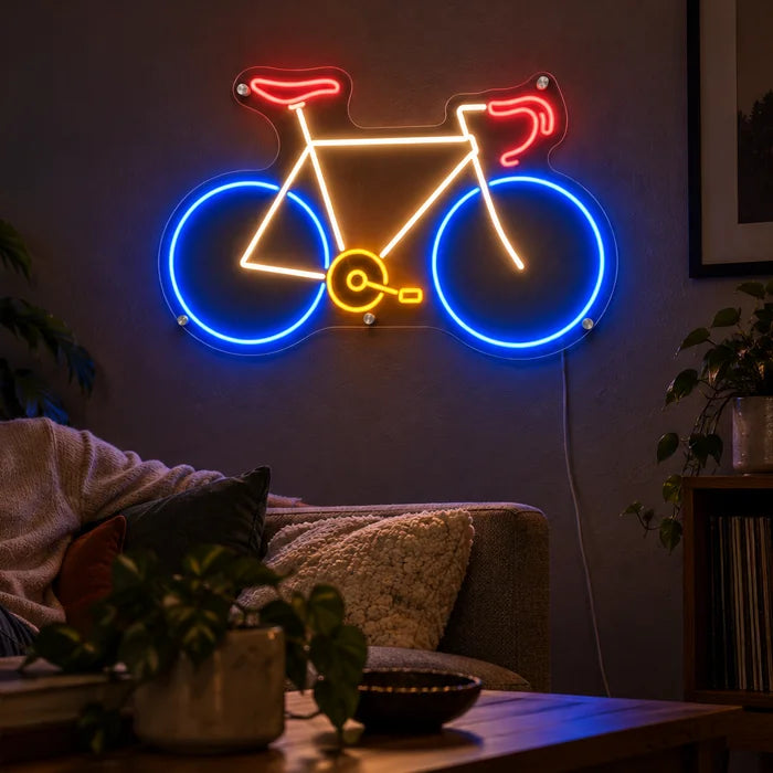 Neon Road Bike Neon LED Sign on a living room wall, a person relaxing on the sofa in front of it