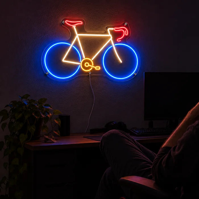 Neon Road Bike Neon LED Sign above a gaming desk, a gamer in a gaming chair in front of it