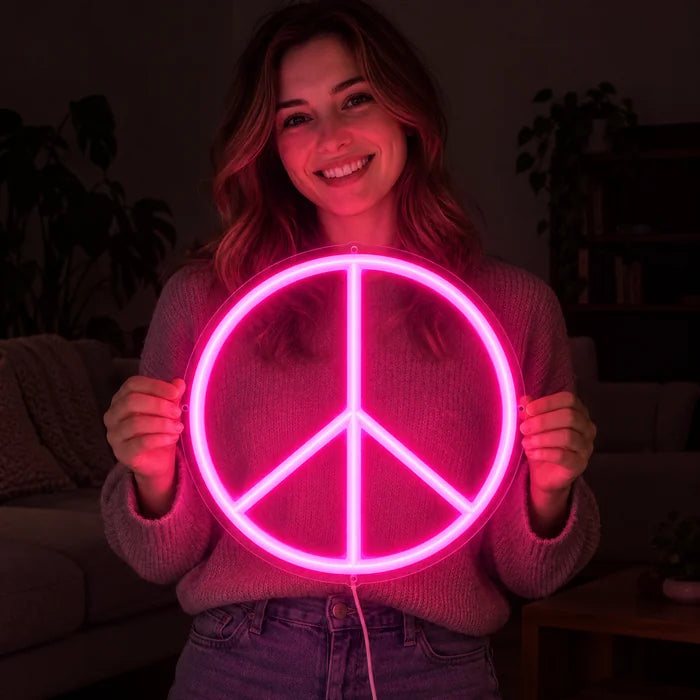 Peace neon LED skilt i hænderne på en smilende kvinde mod mørk baggrund