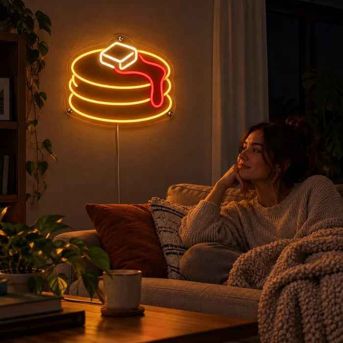 Pancakes Neon LED Sign on a living room wall, a person relaxing on the sofa in front of it