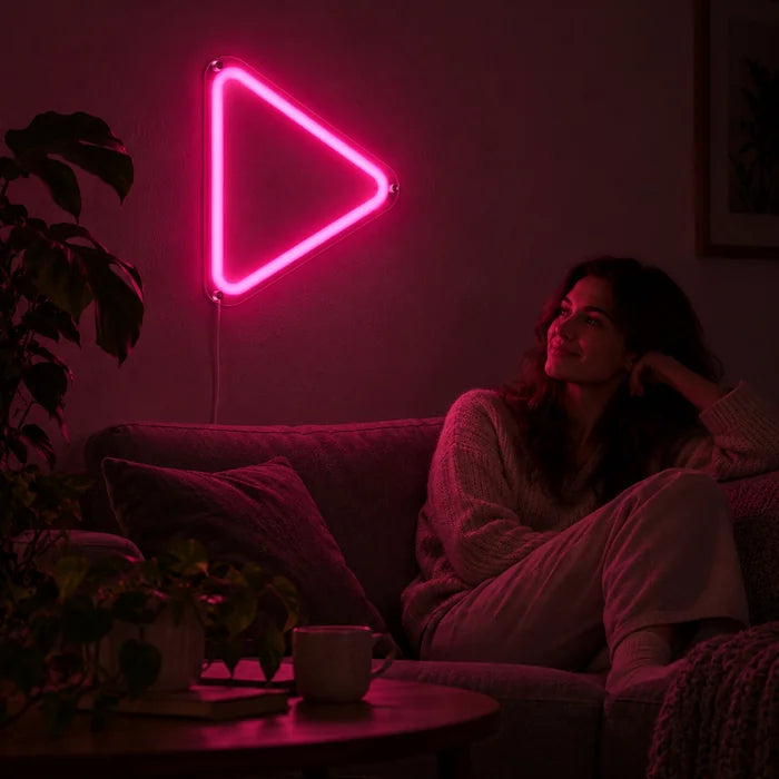 Play Button Neon LED Sign on a living room wall, a person relaxing on the sofa in front of it