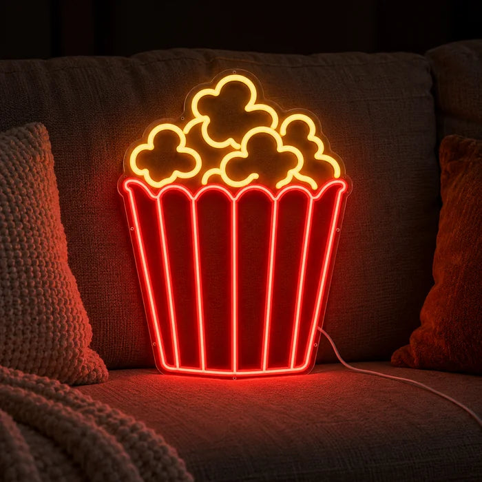 Popcorn Neon LED Sign on a cosy sofa between cushions and a throw