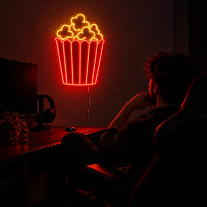 Popcorn Neon LED Sign above a gaming desk, a gamer in a gaming chair in front of it