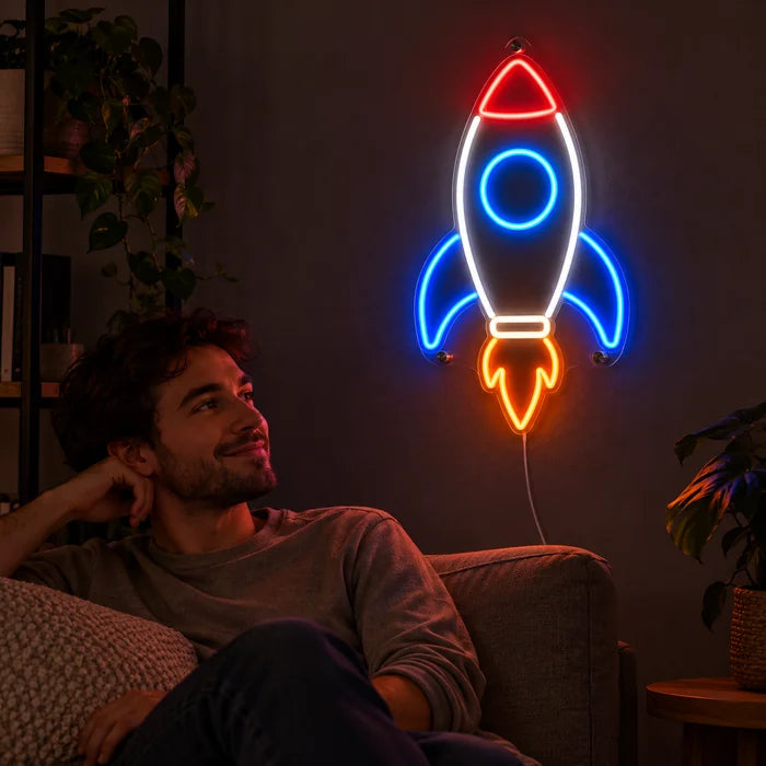 Retro Rocket Neon LED Sign on a living room wall, a person relaxing on the sofa in front of it