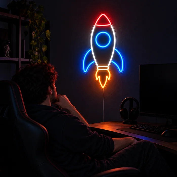 Retro Rocket Neon LED Sign above a gaming desk, a gamer in a gaming chair in front of it