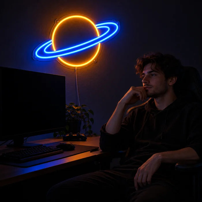 Ringed Planet Neon LED Sign above a gaming desk, a gamer in a gaming chair in front of it
