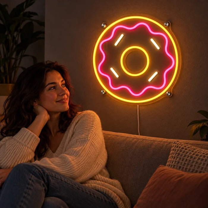 שלט ניאון LED דונאט ורוד על קיר הסלון, לפניו אדם נח על הספה