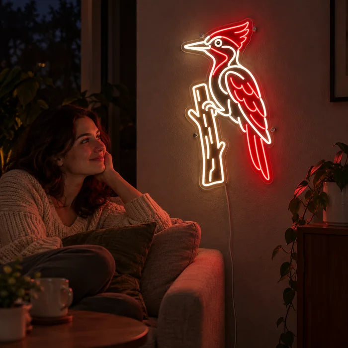 Red Woodpecker Neon LED Sign on a living room wall, a person relaxing on the sofa in front of it