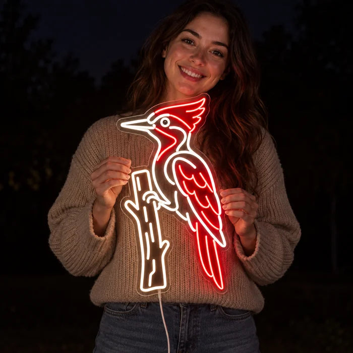 Red Woodpecker Neon LED Sign held by a smiling woman against a dark background