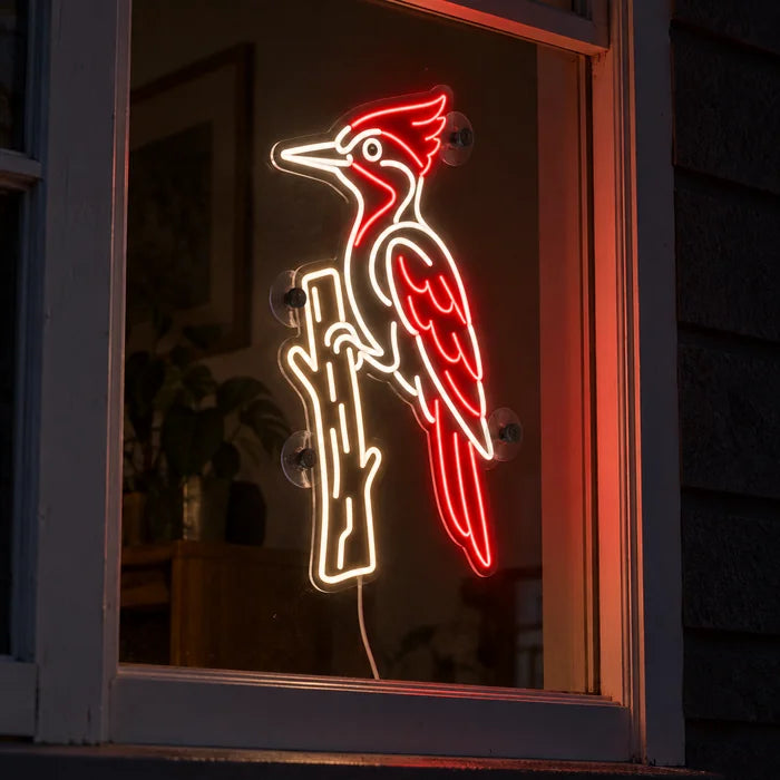 Red Woodpecker Neon LED Sign in a window, seen from the street at night