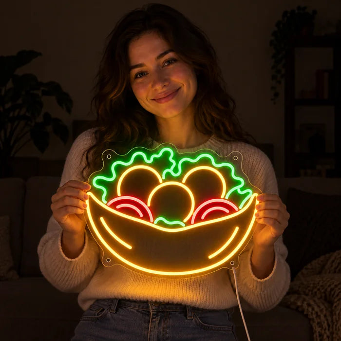 Salad Bowl Neon LED Sign held by a smiling woman against a dark background