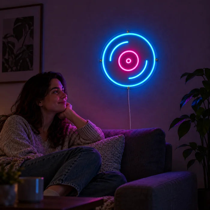 Plak neon LED tabela, oturma odası duvarında, önünde kanepede dinlenen bir kişi