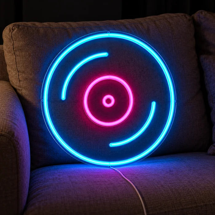 Plak neon LED tabela, yastıklar ve battaniye arasında rahat bir kanepede