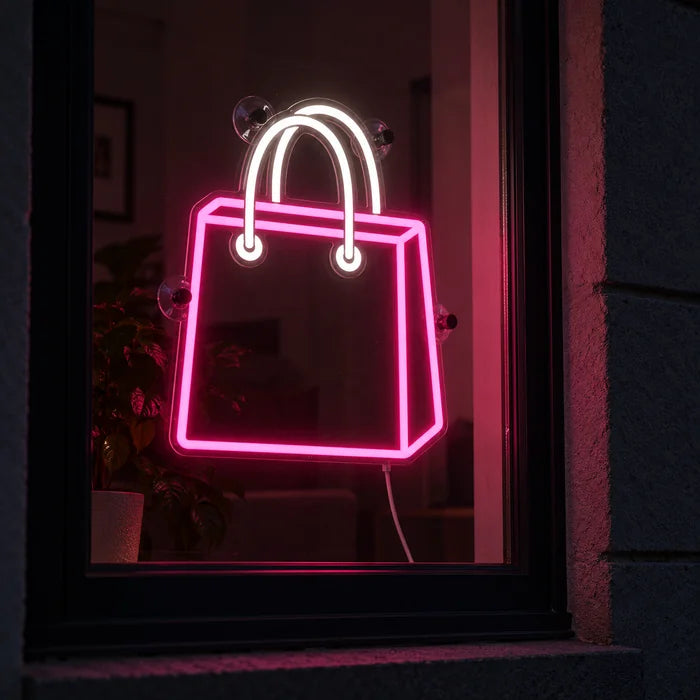Shopping Bag Neon LED Sign in a window, seen from the street at night