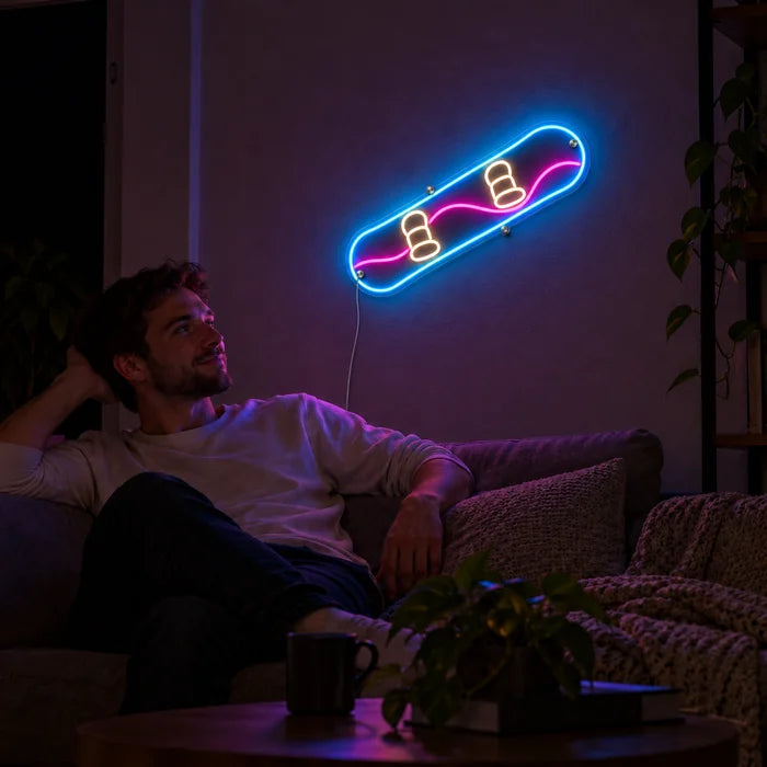 لافتة نيون LED لوح التزلج، على جدار غرفة المعيشة، وأمامها شخص مسترخٍ على الأريكة
