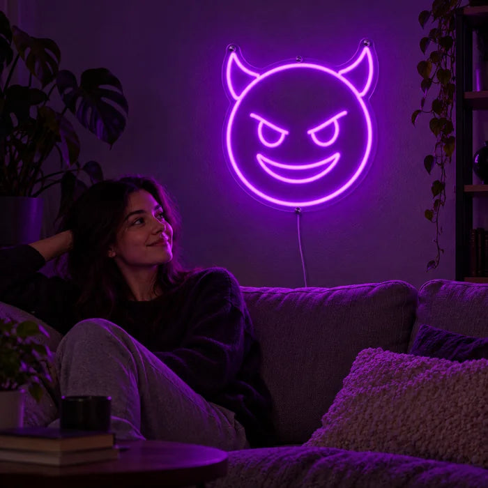 Devil Grin Neon LED Sign on a living room wall, a person relaxing on the sofa in front of it