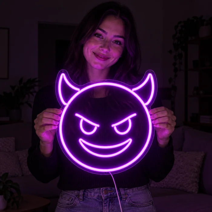 Devil Grin Neon LED Sign held by a smiling woman against a dark background
