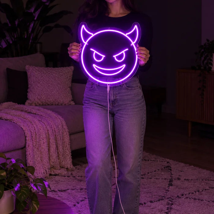 Devil Grin Neon LED Sign held by a woman, showing its size compared to her body