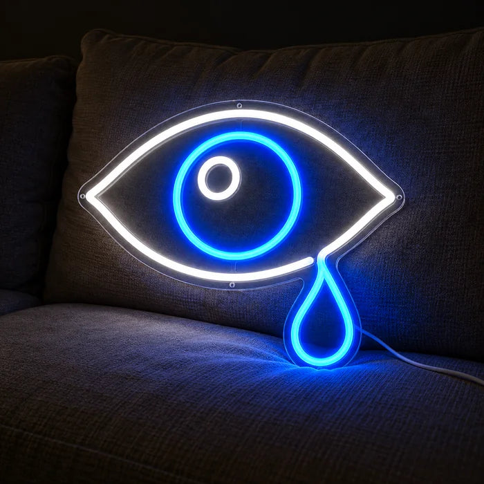 Tåreøje neon LED skilt på en hyggelig sofa mellem puder og tæppe