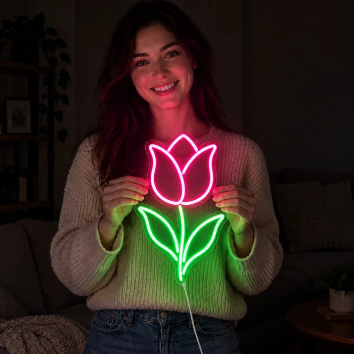 Tulip Neon LED Sign held by a smiling woman against a dark background