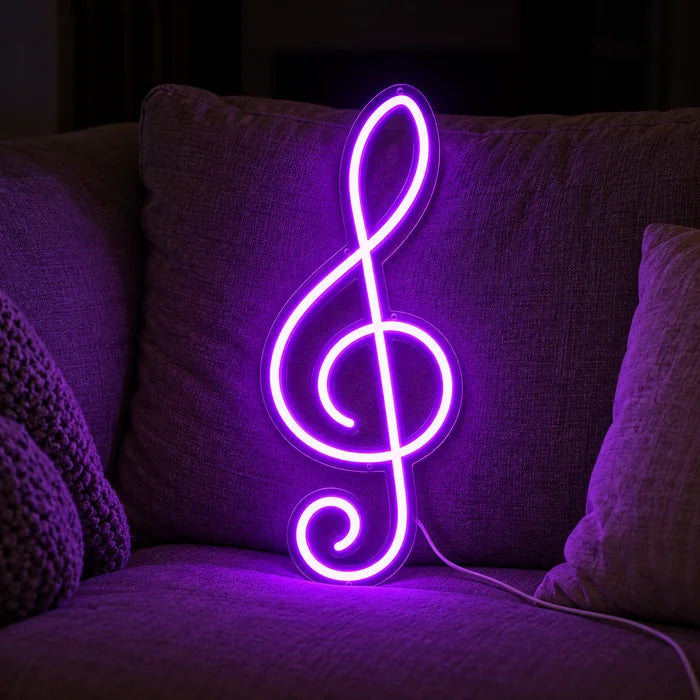 Treble Clef Neon LED Sign on a cosy sofa between cushions and a throw