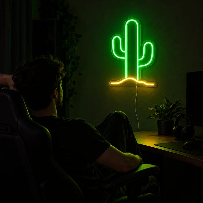 Desert Cactus Neon LED Sign above a gaming desk, a gamer in a gaming chair in front of it