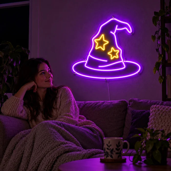 Wizard Hat Neon LED Sign on a living room wall, a person relaxing on the sofa in front of it