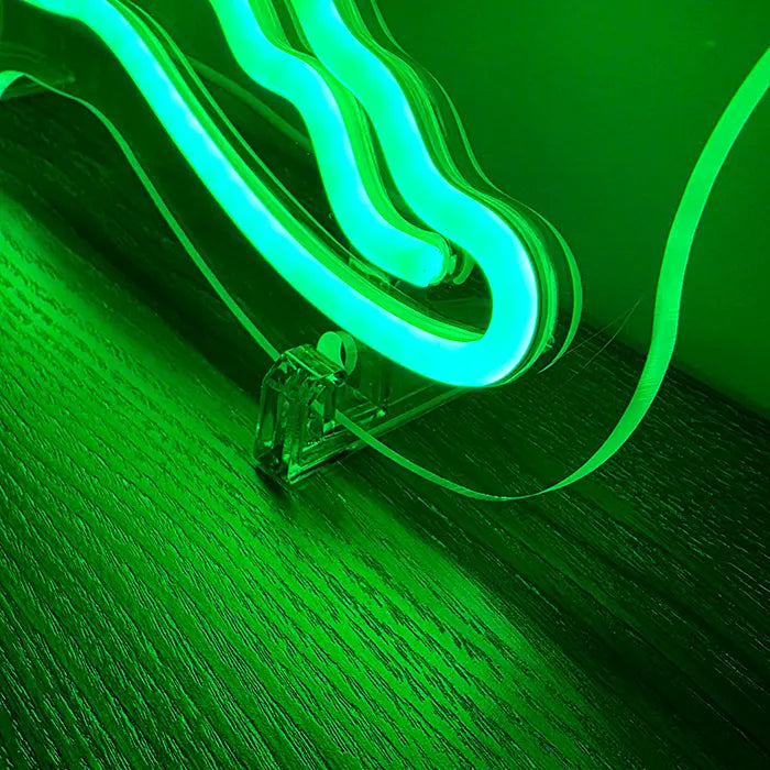 Krokodil Neon LED Schild im Detail: transparenter Standfuß unter der Acrylkante, grün angestrahltes Holz