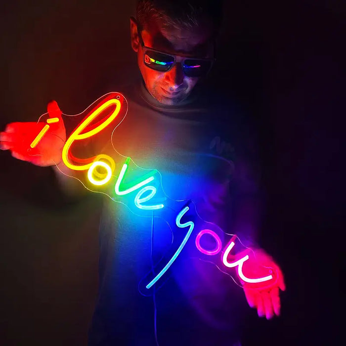 لافتة نيون LED I Love You بخط يدوي مضيء، يحملها شخص أمام جدار داكن