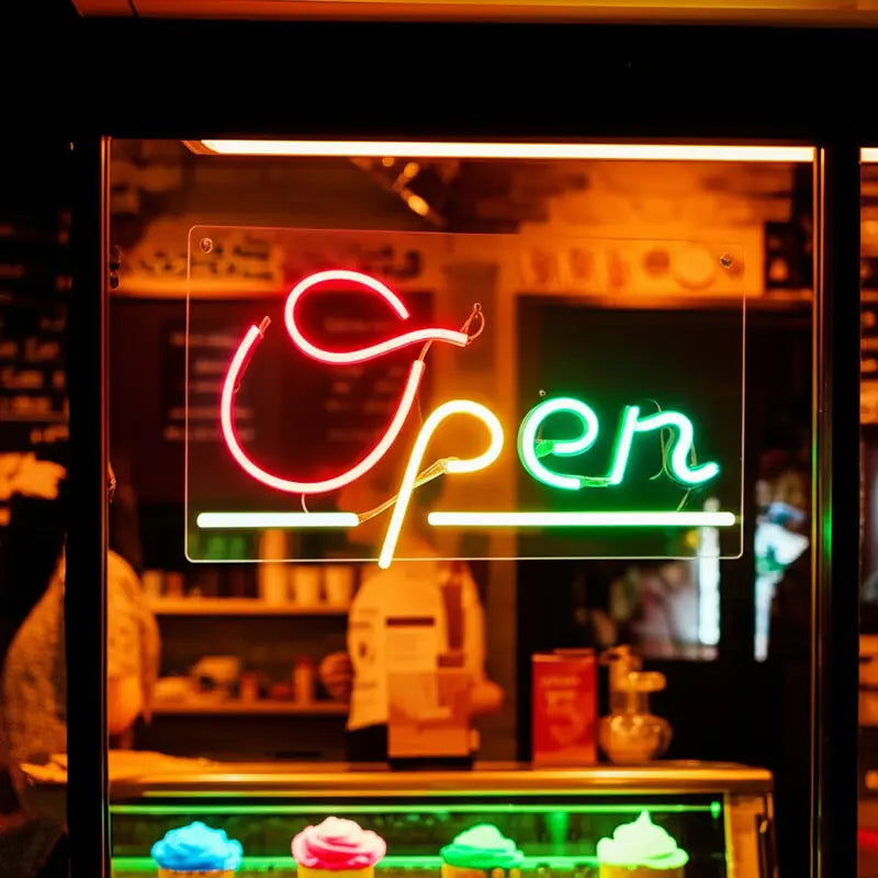 Open Neon LED Schild leuchtet im Schaufenster eines Cafés und zeigt Kundschaft, dass geöffnet ist