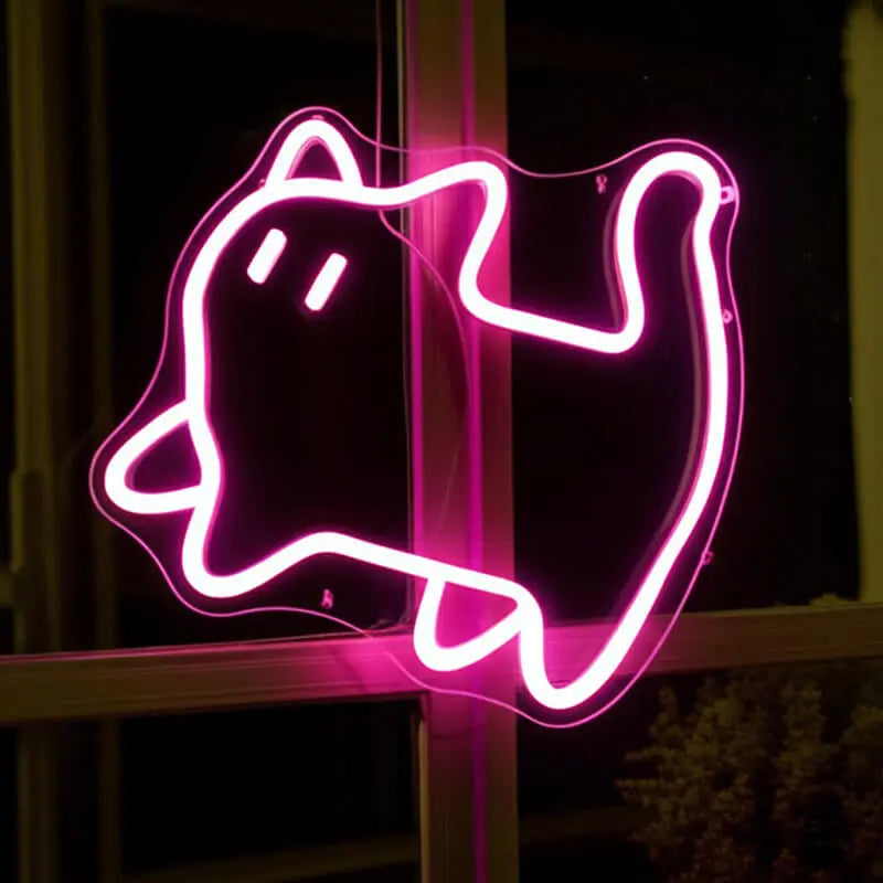 Pinke Katze Neon LED Schild an einem Fensterrahmen bei Nacht, die Katzenkontur leuchtet kräftig rosa