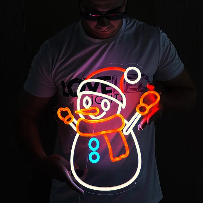 Schneemann Neon LED Schild wird vor hellem Hintergrund gehalten, das leuchtende Motiv in voller Ansicht