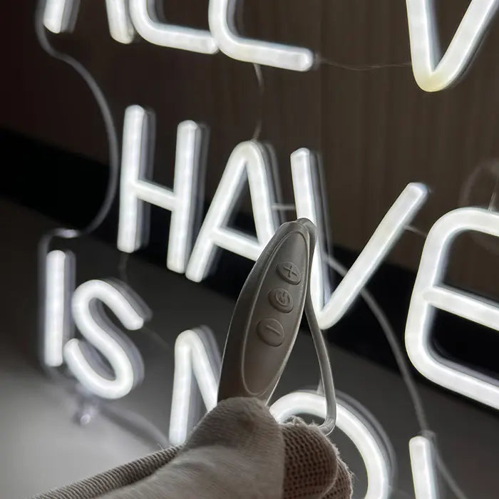 All We Have Is Now Neon LED Schild mit Inline-Dimmer in Nahaufnahme, Plus- und Minus-Taste erkennbar