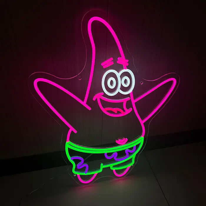 Seestern Neon LED Schild schräg von vorn fotografiert, rosa Konturen und grün leuchtende Badehose im Detail