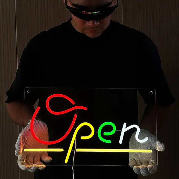 Open Neon LED Schild eingeschaltet, mit Handschuhen gehalten – roter Schriftzug auf klarem Acryl