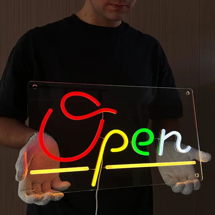 Open Neon LED Schild frontal in zwei Händen, gelbe Unterstrich-Linien und grünes e leuchten