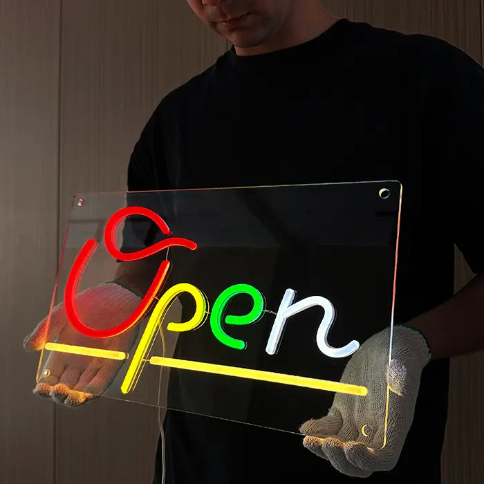 Open Neon LED Schild schräg gehalten, Blick auf die glasklare Acrylplatte mit Bohrlöchern