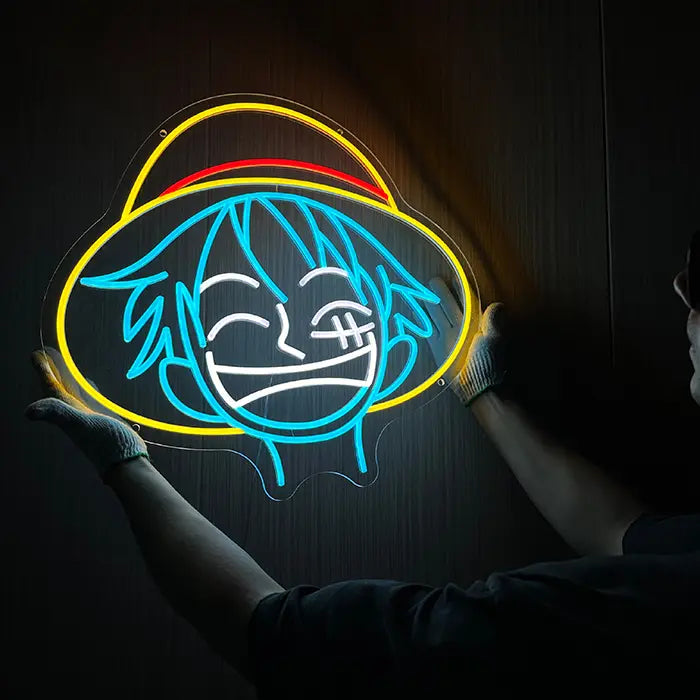 Strohhut Neon LED Schild wird leuchtend an die Wand gehalten, gelber Hut mit rotem Band als Blickfang im Raum