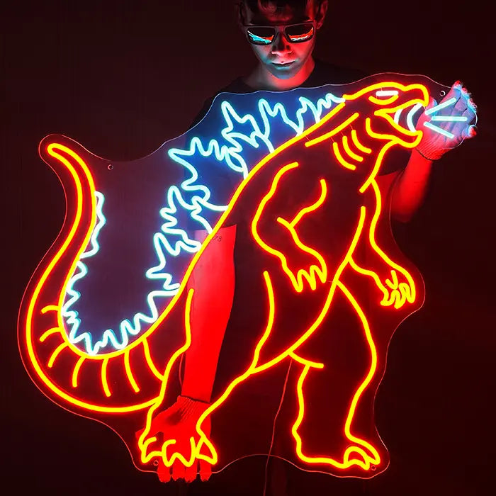 Monsterechse Neon LED Schild wird vor einer dunklen Wand gehalten, Rückenzacken leuchten kräftig blau
