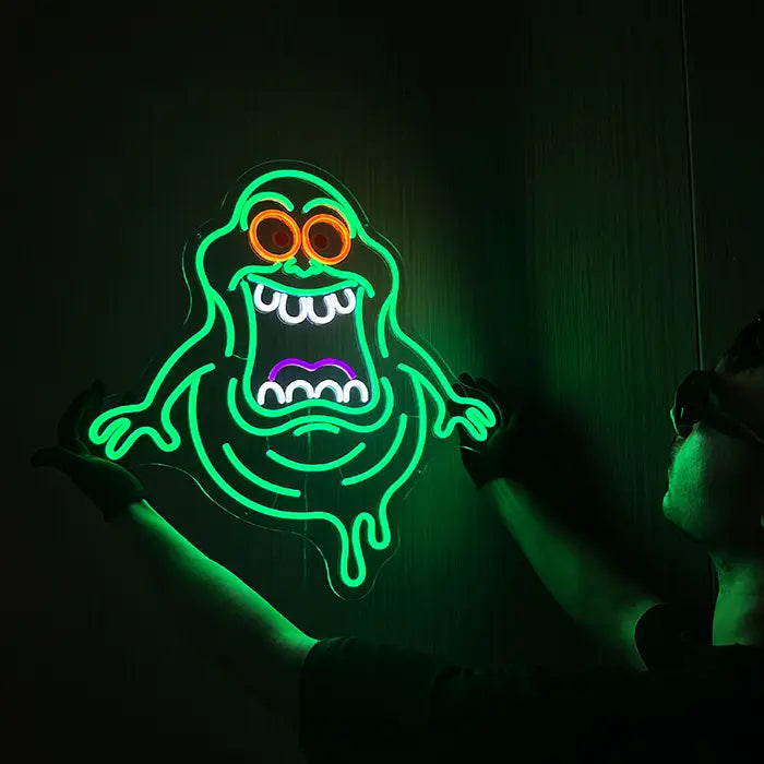 Schleimgeist Neon LED Schild hängt leuchtend an der Wand, das grüne Licht zeichnet die Umrisse der Geistfigur nach