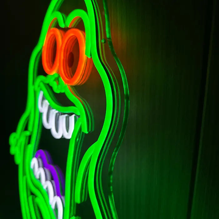 Schleimgeist Neon LED Schild in Nahaufnahme, die orangen Augenringe und weißen Zahnbögen im scharfen Detail