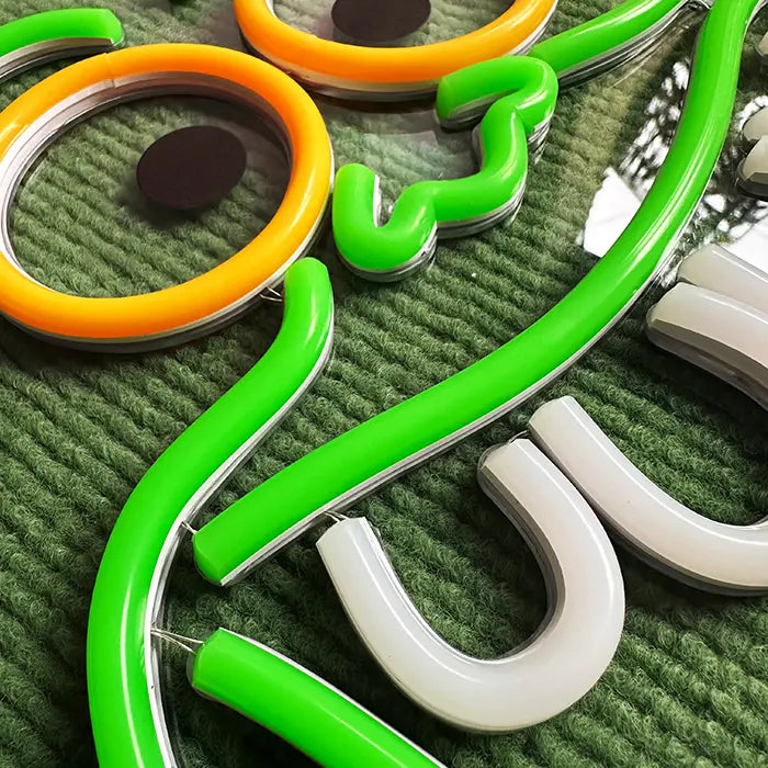 Schleimgeist Neon LED Schild in extremer Detailaufnahme, grüne, weiße und orange Neonschläuche auf der Acrylplatte