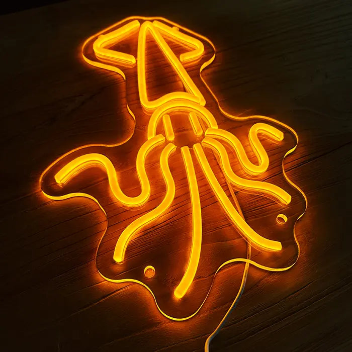 Gold Octopus Neon LED Sign at an angle from above on a wooden surface, the acrylic edge following the contour