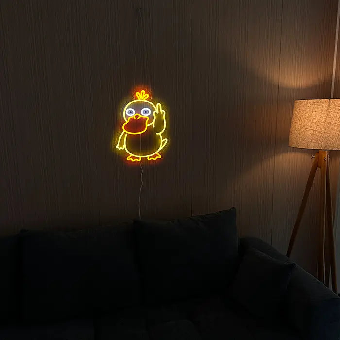 Pokémon Psyduck Middle Finger Neon LED Sign on a dark wall above a sofa, a floor lamp beside it
